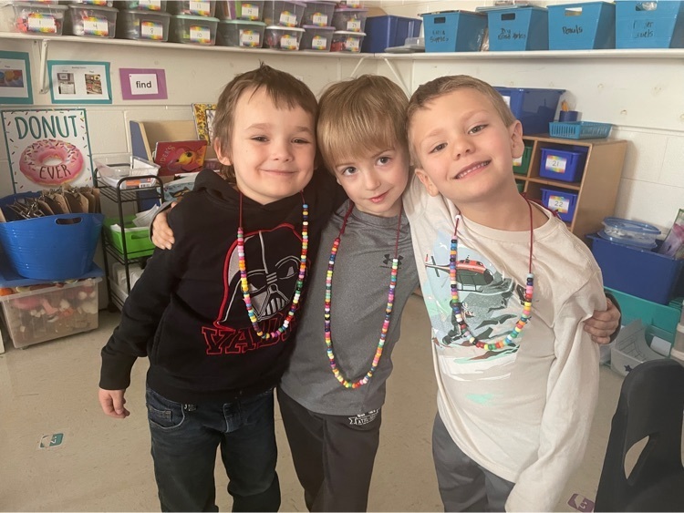 students smiling with bead necklace 